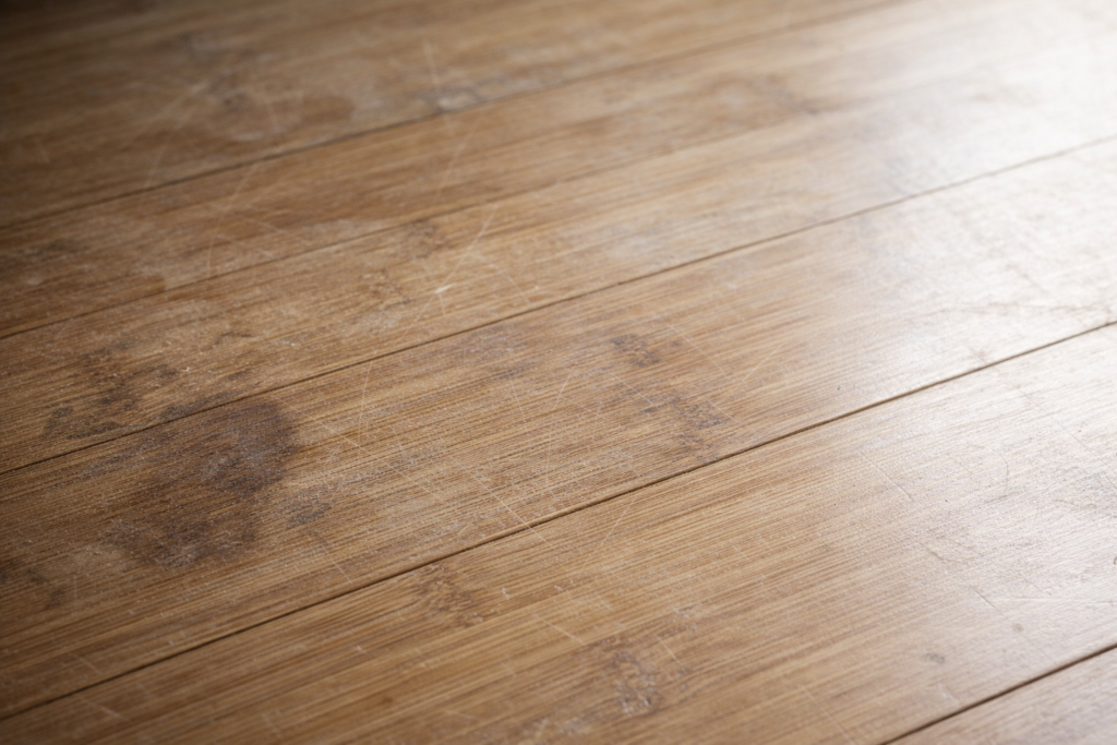 Slidt bambus gulv med ridser, pletter og mat overflade i naturligt lys